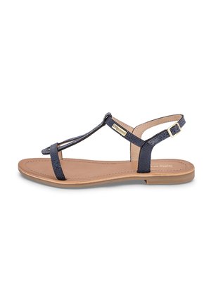 Navy blue sandal featuring a textured upper, slender straps, adjustable ankle buckle, and a flat beige sole. Simple and minimalist design.