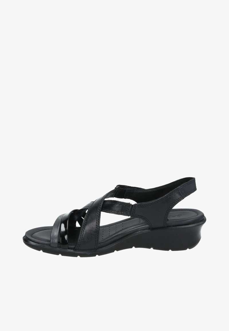 Sandale compensée en cuir noir pour femmes avec brides croisées, bout ouvert et bride arrière réglable, conçue pour le confort et une tenue décontractée.