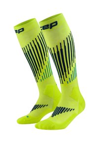 Calcetines deportivos de color amarillo brillante hasta la rodilla, con patrones de rayas verticales en azul oscuro y azul claro, y con acolchado alrededor del tobillo y el pie.