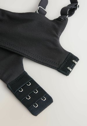 Črni modrček z nastavljivimi naramnicami, teksturirano tkanino in kovinskimi zapiranji na kavljice. Ima gladke šive in strukturirano obliko.