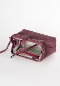 Borsa in pelle bordeaux con una texture liscia, chiusura a zip e fodera in tessuto a strisce. Include una piccola tasca interna con una cerniera rossa.