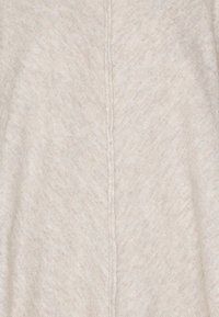 Světlé šedé pletené látky s jemnou strukturou, která má viditelný šev uprostřed, čímž vytváří jednoduchý, minimalistický design.