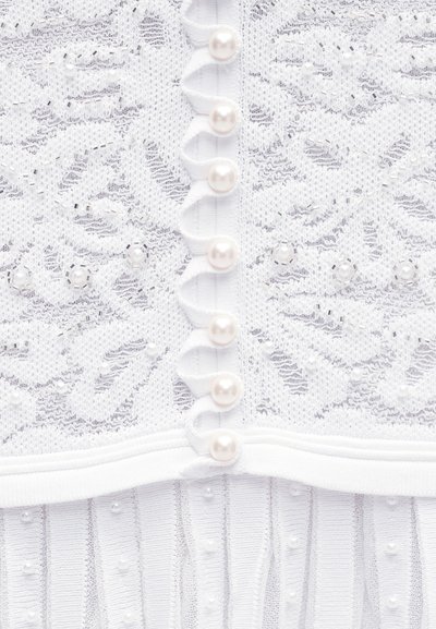 Bílá krajka s květinovými vzory, perleťové knoflíky v svislém řádku a drobné korálkové ozdoby na pleteném materiálu níže.