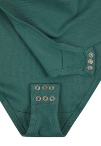 Bodysuit vert côtelé avec des fermetures à pression aux épaules et en bas. Texture lisse avec des lignes verticales et des pressions métalliques.