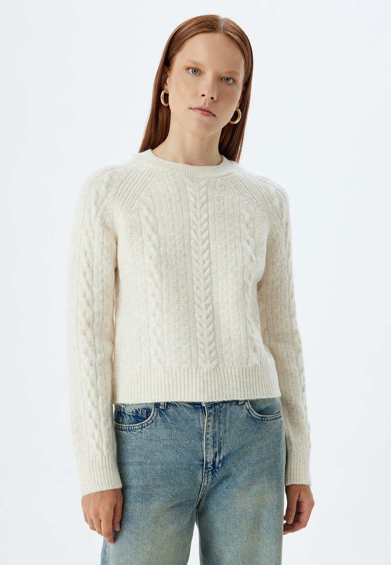 Cremfarbener Ringelstrickpullover mit Rundhalsausschnitt, geripptem Saum und Bündchen, ausgestattet mit einem strukturierten Muster und einem leicht verkürzten Schnitt.