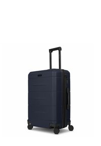 Marineblauer Hartschalenkoffer mit strukturierter Oberfläche, vier Rollen, ausziehbarem Griff und Reißverschluss. Verfügt über einen seitlichen Griff für einfaches Anheben.