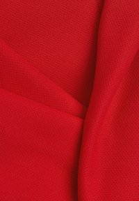 Rood textiel met een dichte weving, met gladde en licht glanzende delen, gerangschikt in overlappende plooien.