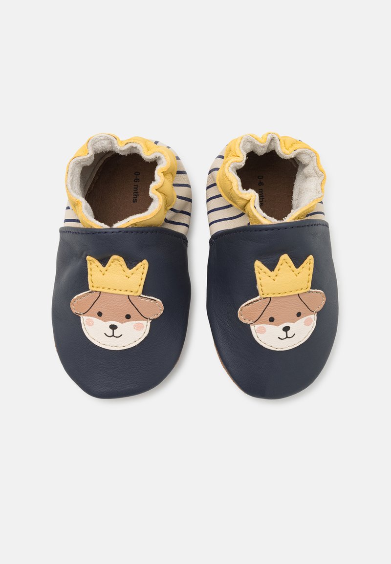 Chaussures pour bébés en cuir bleu marine avec un motif de visage de chien et de couronne. Doublure en coton doux et finition en dentelle jaune. Motif rayé sur le dessus.