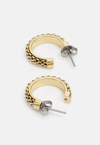 Złote kolczyki w kształcie kół o fakturowanym wzorze z małymi kwadratowymi akcentami. Zawierają srebrny stoper zapewniający pewne zamocowanie.