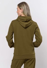 Olijfgroene hoodie met trekkoordkap en lange mouwen. Zachte stof, licht getailleerd ontwerp, centrale achternaad en geribbelde boorden.