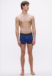 Tengerészkék boxeralsó könnyű anyagból, apró Polo logó ismétlődő mintával és fekete derékpánttal, amelyen a "POLO RALPH LAUREN" felirat olvasható.