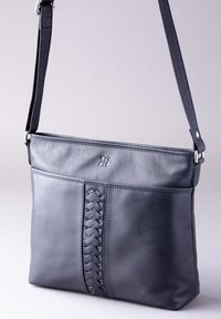 Dark gray leather shoulder bag with a woven detail on the front. It features a flat design and an adjustable strap for easy wearing.