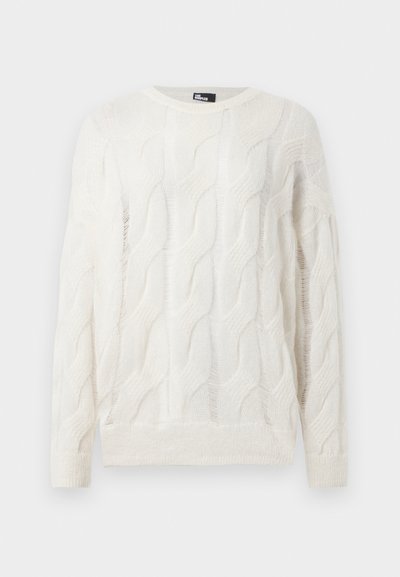 Hvid strikket sweater med et kabelstrik mønster, rund halsudskæring og lange ærmer. Teksturen virker blød og let gennemsigtig.