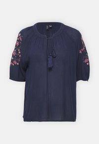 Mörkblå blus med rund halsringning, knytstängning och blommig broderi på ärmarna. Tillverkad av lätt, texturerad tyg.