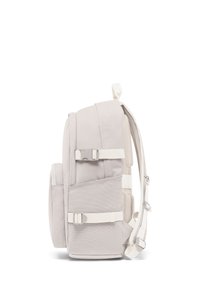 Sac à dos gris clair avec des bretelles réglables, tissu texturé, poche en mesh latérale et boucle sur le côté. Il dispose d'un dos rembourré pour plus de confort.