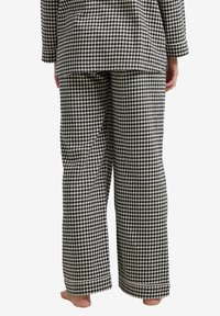 Black and white gingham check pajama set featuring loose-fitting top and pants, with a straight cut and relaxed structure.
