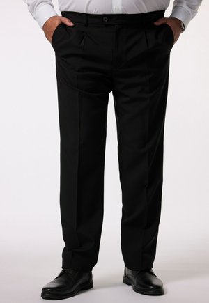 Schwarze Anzughosen mit gefaltetem Vorderteil, seitlichen Taschen und einem Knopfverschluss, aus einem glatten Stoff gefertigt. Getragen mit schwarzen Schuhen.