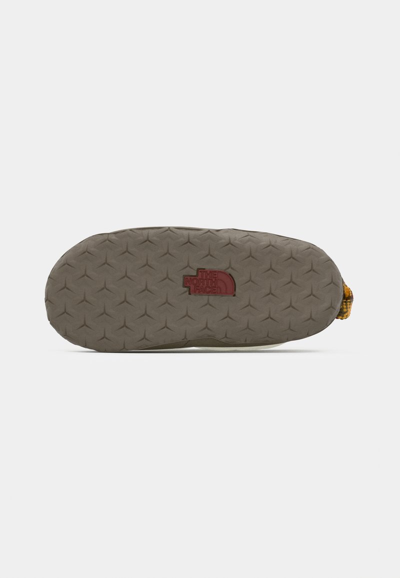 Gummisohle in Grau mit einem strukturierten Muster aus Dreiecken, auf der Unterseite mit einem eingeprägten roten Logo von "The North Face".