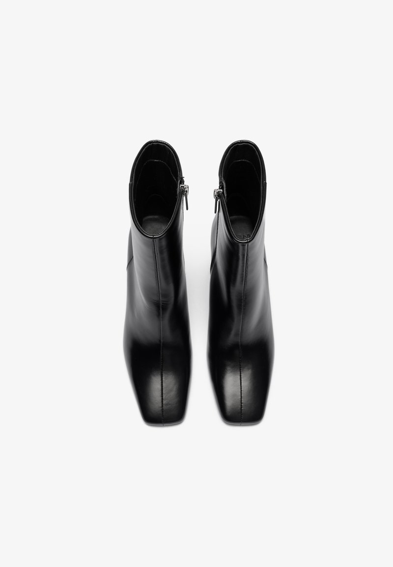 Czarne skórzane botki za kostkę o gładkiej fakturze, szpiczastej czubku i bocznych zamkach, charakteryzujące się eleganckim, minimalistycznym wzornictwem.