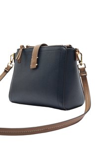 Strukturalna torebka w granatowej, teksturowanej skórze, z brązowym paskiem i złotymi elementami, zamykana na zamek błyskawiczny u góry, z bocznymi zdobieniami w postaci frędzli.