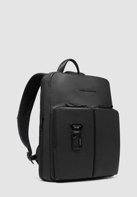 Zwart leren rugzak met een gestructureerd ontwerp, voorzien van een handvat aan de bovenkant, verstelbare schouderbanden en een voorvak met hardwaredetails.