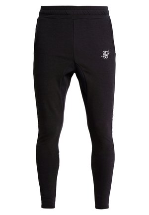 Pantalon de jogging noir slim avec ceinture élastique et petit logo blanc sur la partie supérieure de la cuisse gauche.