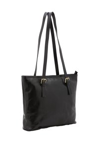 Zwarte leren tote bag met twee lange handvatten, een platte body, een gladde textuur en sluitingaccenten op de banden. Minimalistisch ontwerp.