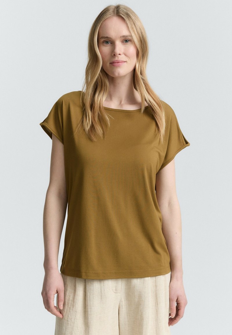 T-shirt a maniche corte, verde oliva, con scollo rotondo e vestibilità rilassata, realizzata in tessuto morbido e liscio.