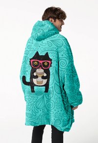 Türkiser übergroßer Hoodie mit einer Grafik eines schwarzen Katers, der eine Tasse Kaffee hält, auf der Rückseite, geschmückt mit rosa Brille vor einem gemusterten Hintergrund.