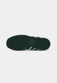 Green rubber sole with diamond-patterned texture, featuring white and black striped accents on the side.