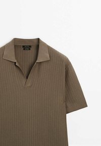 Polo à manches courtes, en jersey côtelé, de couleur vert olive, avec un col en V et un col plat. Fabriqué en matière tricotée texturée avec de subtils rayures verticales.