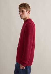 Roter, strukturierten Strickpullover mit langen Ärmeln und rundem Ausschnitt. Rippbündchen und Saum, mit einem lässigen Schnitt gestaltet.