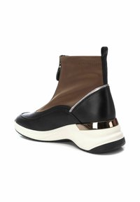 Bota deportiva de cuero negro y material sintético marrón. Cuenta con un diseño sin cordones, un acento metálico en el talón y una superficie texturizada.