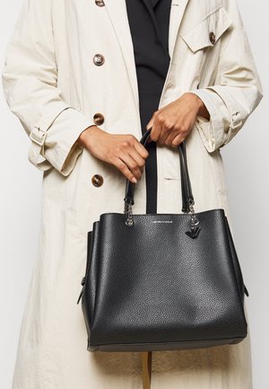 Borsa a mano in pelle nera con finitura texturizzata, doppi manici superiori e dettaglio in metallo color argento. Presenta una forma strutturata e un dettaglio del logo.