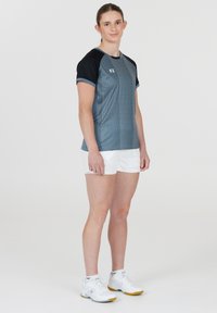 Grå och svart idrottstopp med korta ärmar och randig struktur, i kombination med vita shorts och vita träningsskor. FZ-logotyp på bröstet.