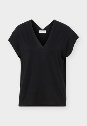 Μαύρο τοπ με κοντά μανίκια, V-λαιμόκοψη και λουριά που διασταυρώνονται στην πλάτη, κατασκευασμένο από απαλό ύφασμα, τοποθετημένο σε απλό φωτεινό φόντο.