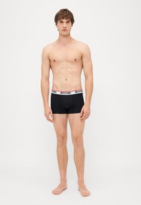Fekete boxeralsó fehér és piros "Moschino" logóval ellátott elasztikus derékpánttal. Simaság, testhezálló design és combközépig érő szabás.