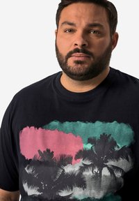 Černé bavlněné tričko s grafickým designem s palmami, barevnými akcenty v růžové, tyrkysové a šedé barvě a kulatým výstřihem.