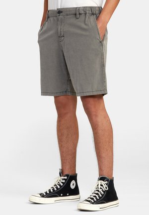 Gray cotton shorts with a waistband, front pockets, and a straight cut. Paired with black high-top sneakers with white accents.