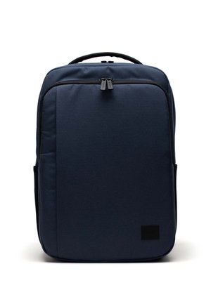 Navyblauer Rucksack aus robustem Stoff, mit rechteckiger Form, zwei Reißverschlussschiebern und einem schwarzen Logo-Patch auf der Vorderseite.