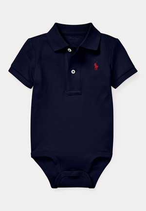 Ādas zilo polo kombinezonu, kas izgatavots no kokvilnas, ar sarkanu izšūtu logo, trim baltām pogām un snap aizdari apakšā. Īsas piedurknes.
