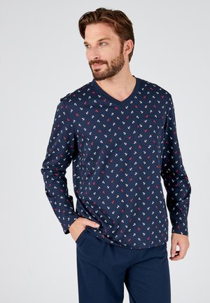 Chemise à manches longues bleu marine avec un col en V, une petite poche sur la poitrine et des motifs d'ancres blanches et rouges dispersés sur un tissu doux et respirant.