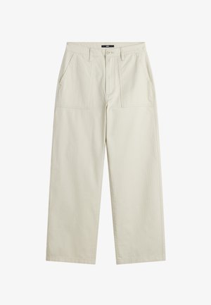 Beige broek met wijde pijpen, voorzakken met klep, riemlussen, knoopsluiting en een Vans-label op de tailleband.