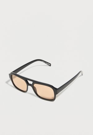 Schwarze rechteckige Sonnenbrille mit dünnen, beigefarben getönten Gläsern und einem Schlüsselsteg, mit der Marke ALDO am Bügel.
