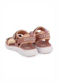 Sandalias rosas y beige con correas ajustables, tela texturizada y suelas de goma blancas. Presentan "CRECIENDO DESDE" en la correa trasera.