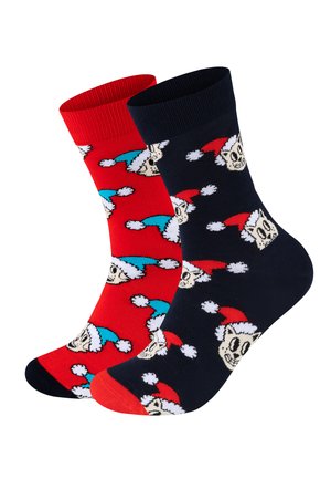 Two pairs of cotton socks: one red with cartoon skulls in Santa hats, and one navy blue with the same pattern, featuring contrasting toe and cuff accents.