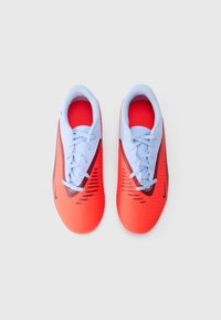 Football shoes with a red and light blue color scheme, featuring a smooth upper, textured accents, and black detailing on the sides.