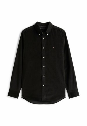 Camicia in velluto a coste nera con colletto a bottone, maniche lunghe, bottoni bianchi e un piccolo logo sul petto. Orlo leggermente curvo.