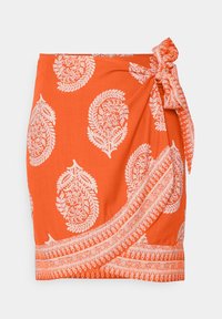 Falda envolvente en tela de un vibrante color naranja con patrones de paisley blancos. Presenta un lazo en un lado y un dobladillo con un elaborado diseño.