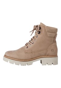 Stivaletto alla caviglia in suede tan con lacci marroni, occhielli in argento e suola spessa bianca. Presenta un colletto imbottito e cuciture decorative.